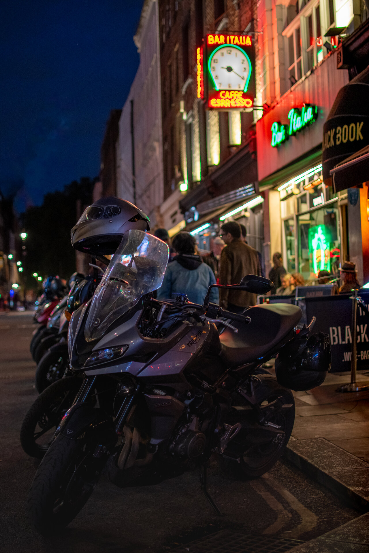 Motorcyclist on rain-slicked Soho street at night