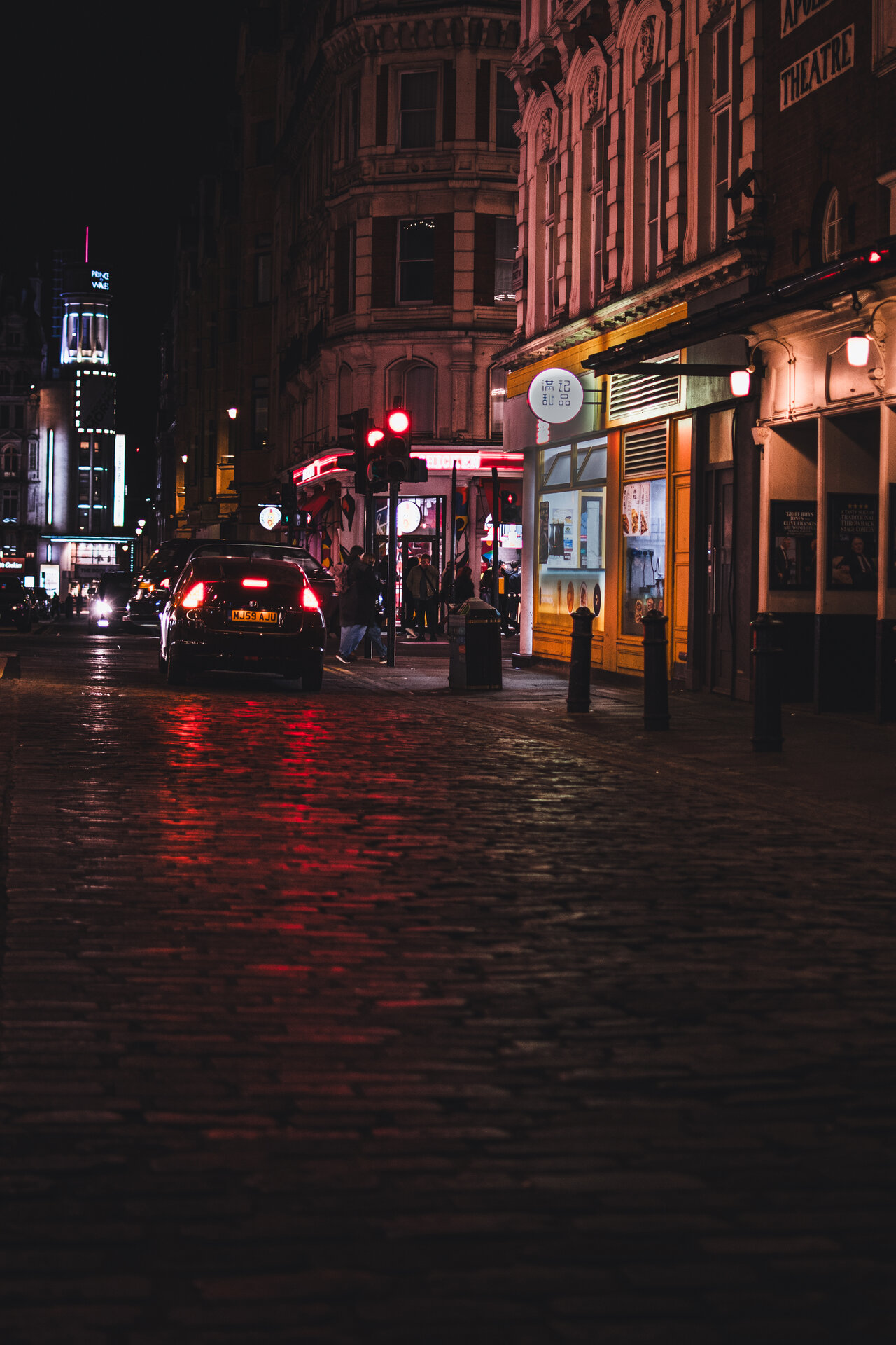 Colors of London nightlife reflecting in rain-wet pavement