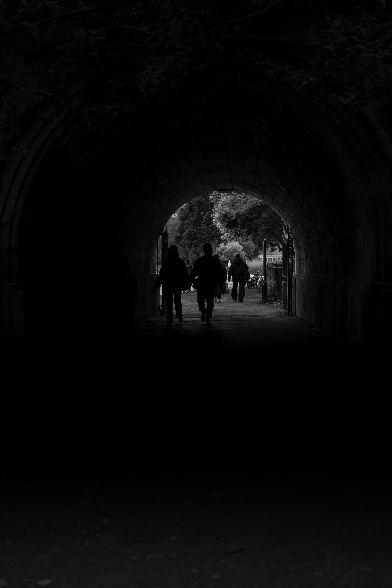 Silhouetted figure at the far end of a dark tunnel, pinpoint of light beyond