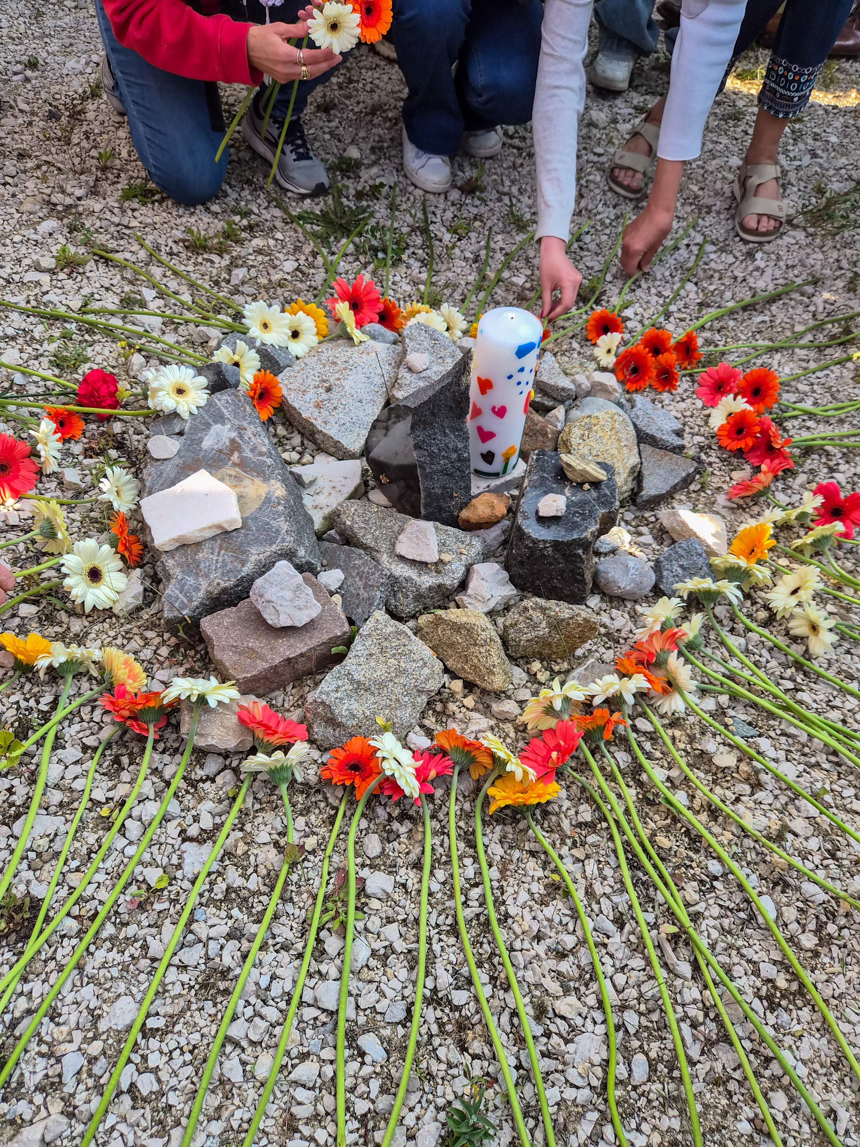 Flowers placed around a candle and granite stones at the Gusen ceremony