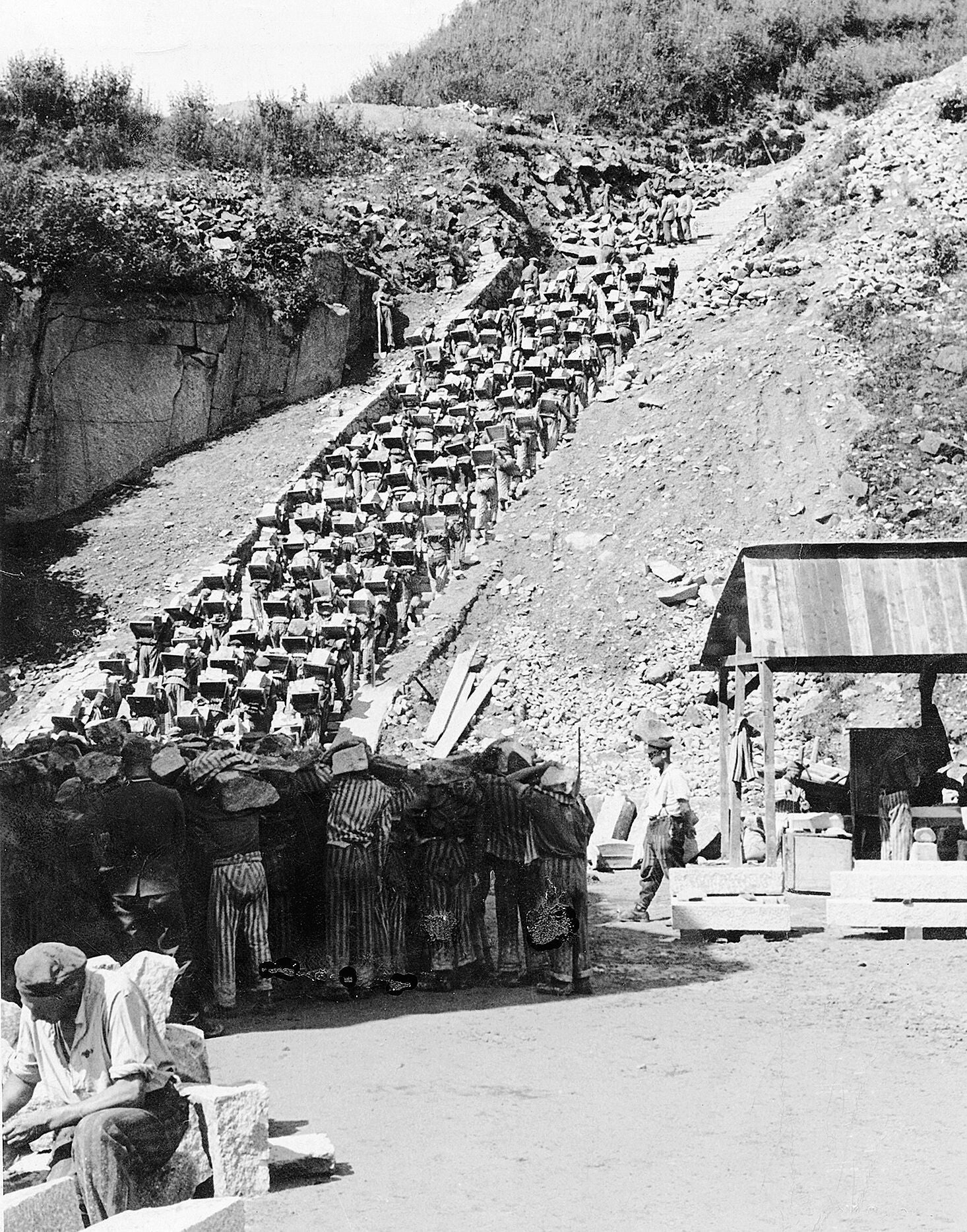 Prisoners carrying granite blocks up the Stairs of Death, approximately 1942
