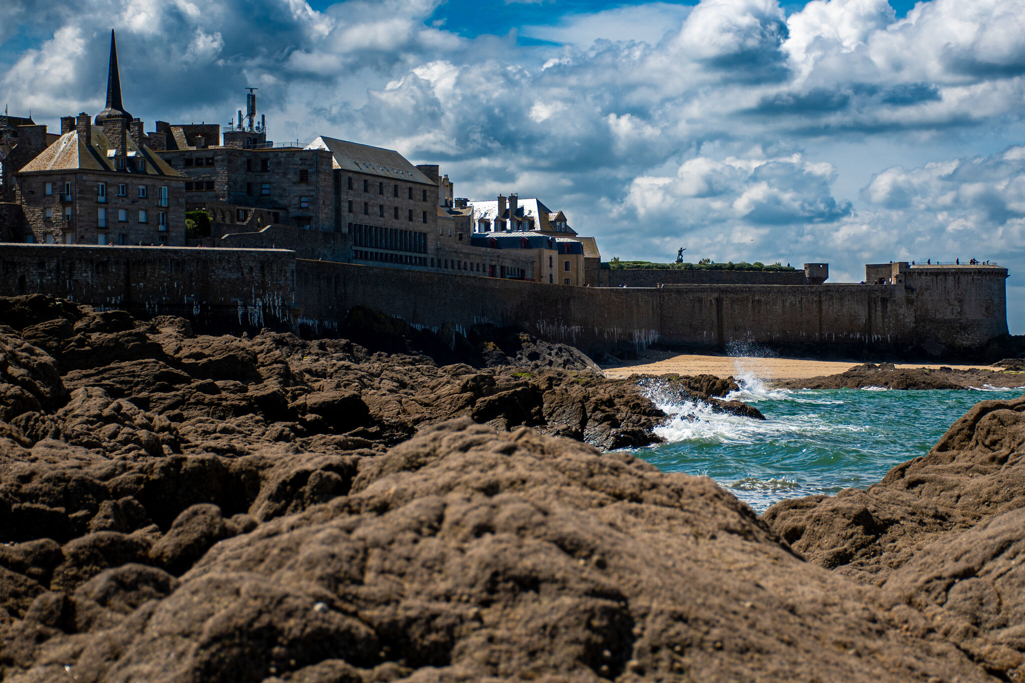 The walled city of Saint-Malo seen from the tidal rocks, Atlantic breaking against the base of the walls