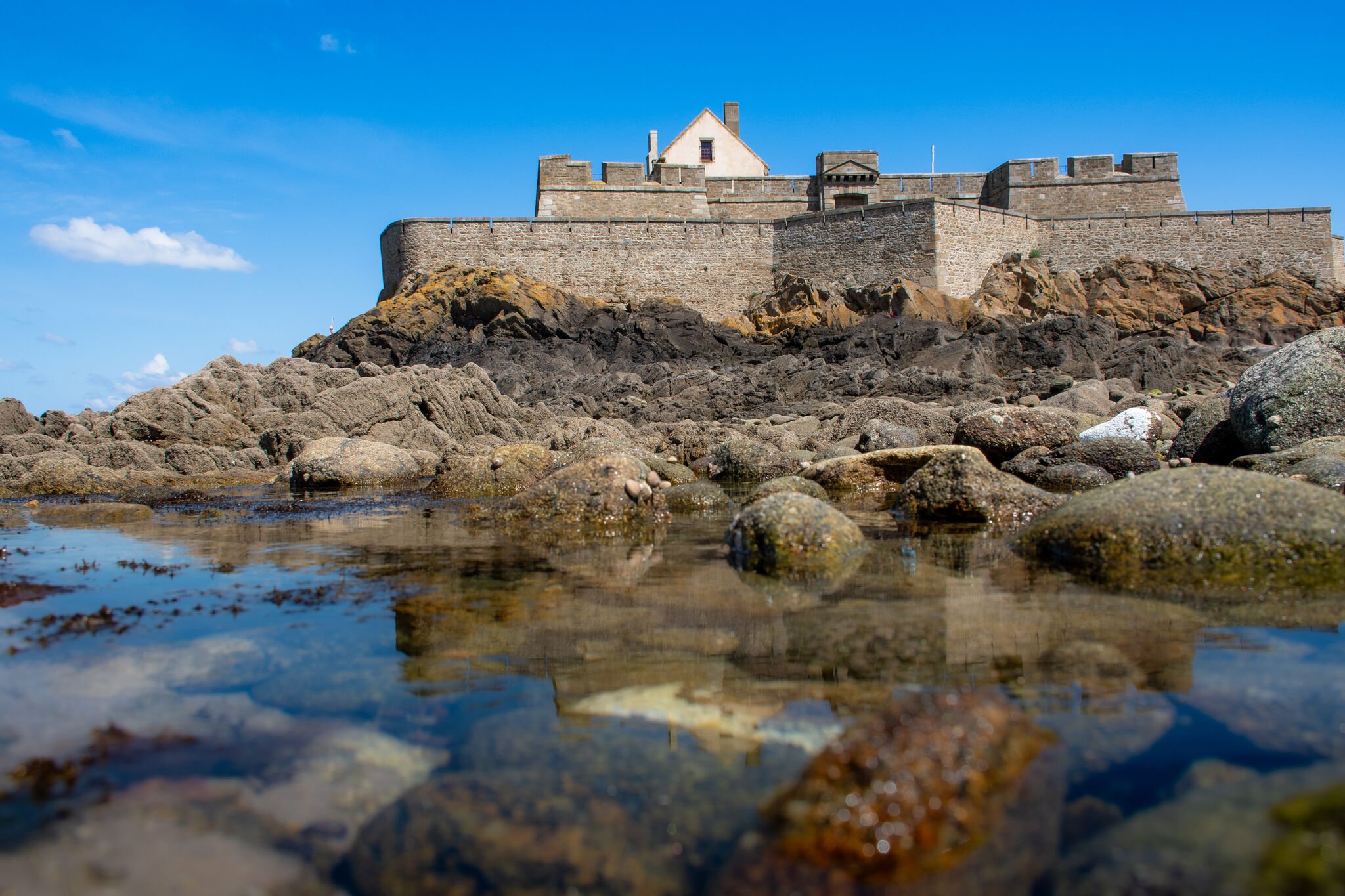 Fort National island fortress seen from close range across tidal pools