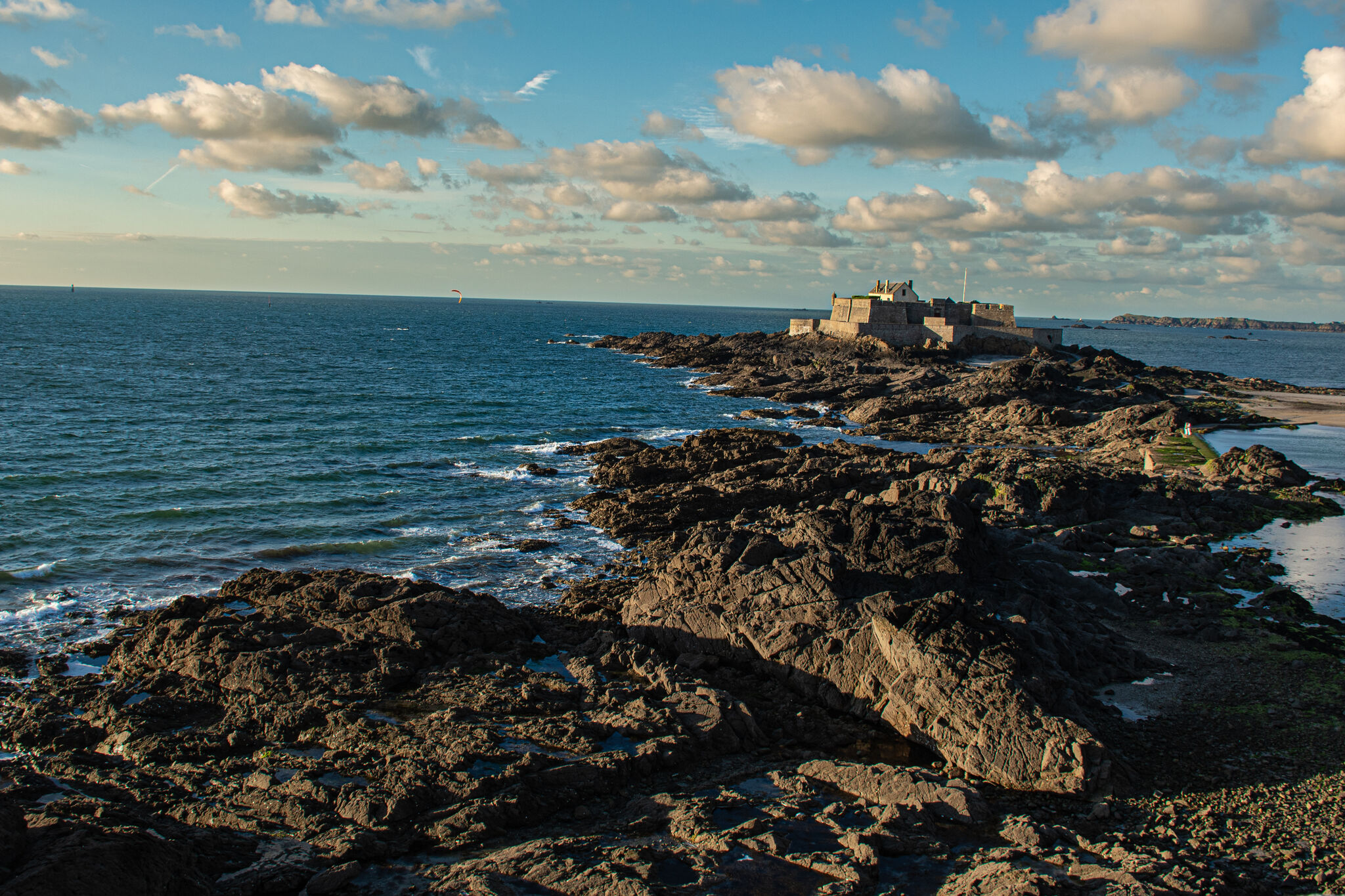 Fort National seen from the ramparts in afternoon light, tidal rocks and sea