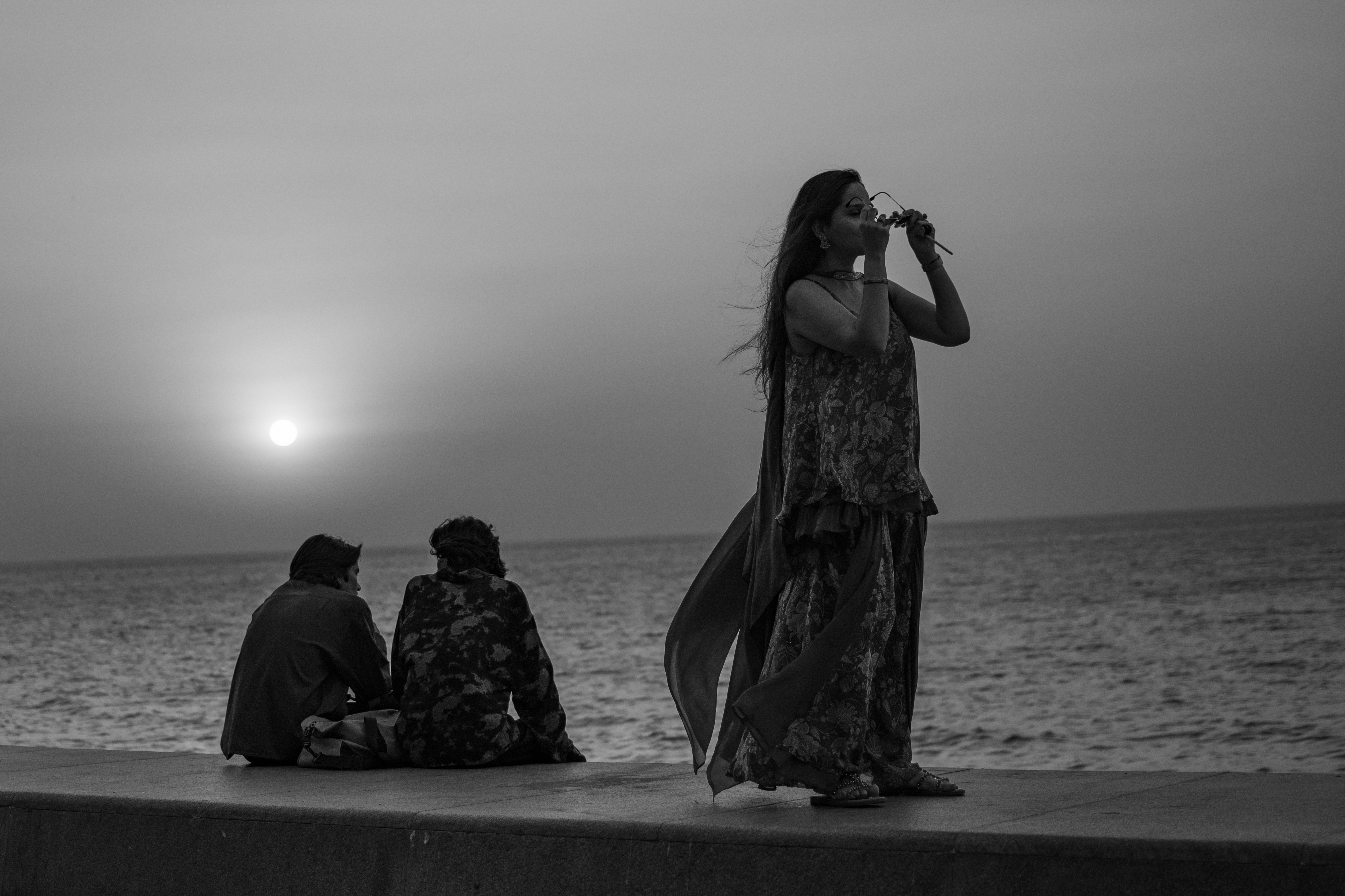 Mumbai sunset, windswept woman at the sea wall